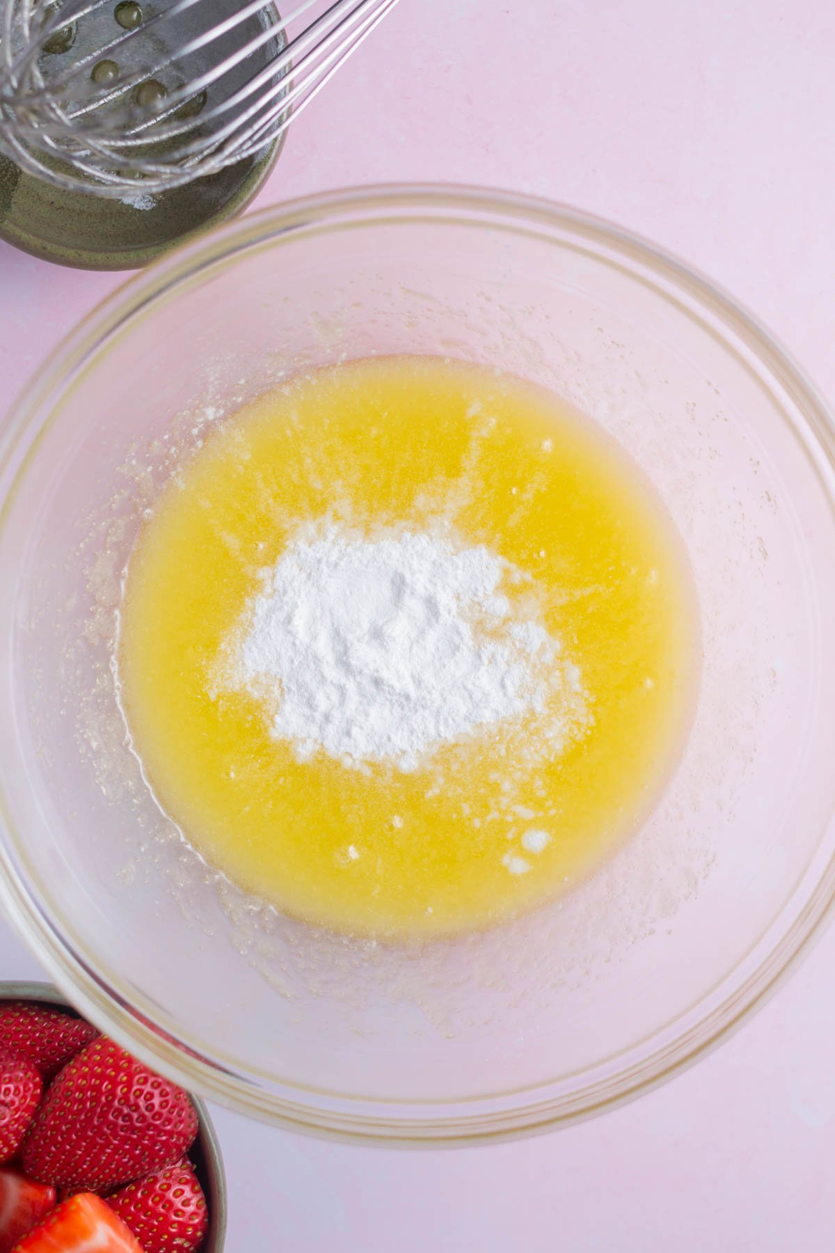 baking powder and salt on top of whisked sugar and melted butter in a bowl