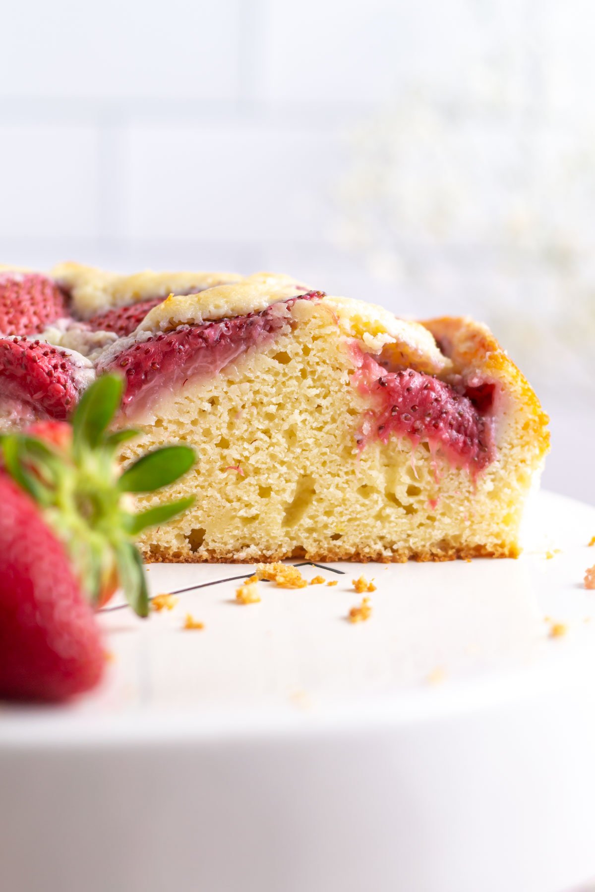 slice of strawberry vanilla cake on a cake stand