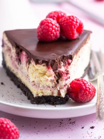 slice of chocolate raspberry cheesecake on a plate with a fork