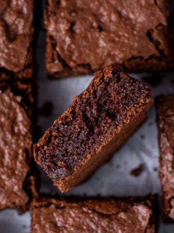 Almond flour brownie on it's side showing fudgy middle