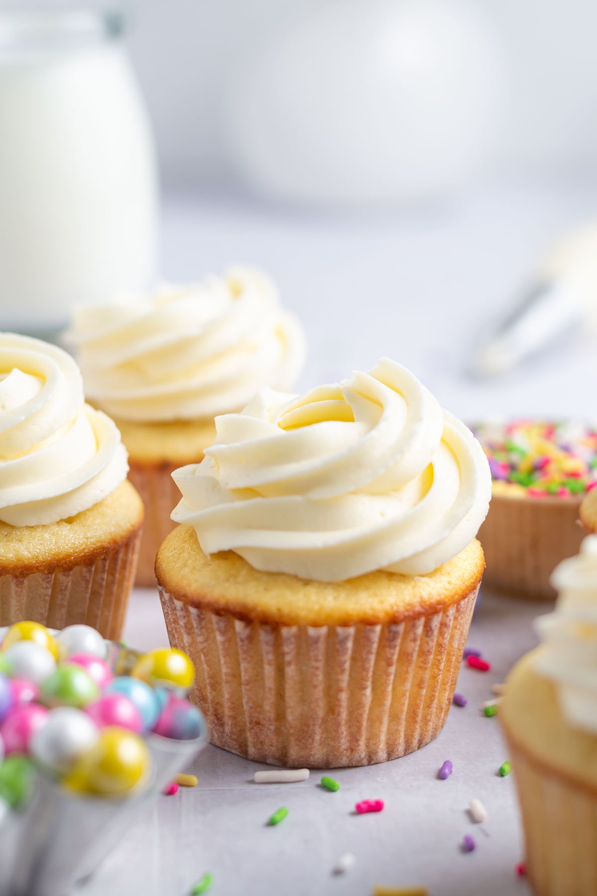 Easy vanilla cupcakes with a glass of milk and sprinkles