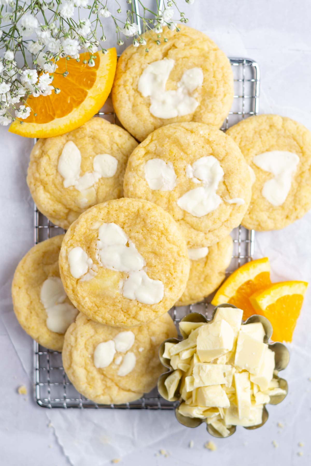 cookies on a cooling rack with orange slices and white chocolate