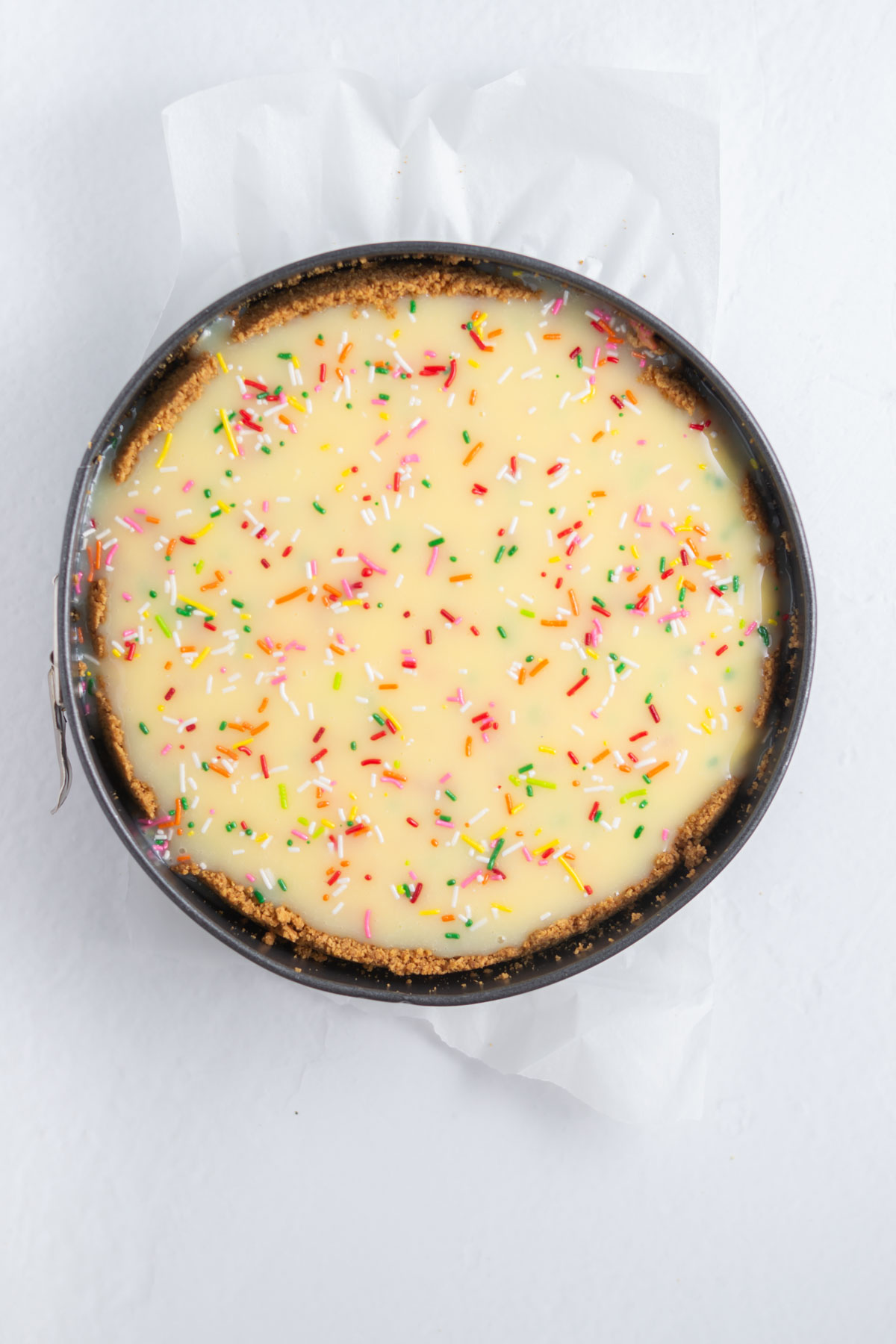 birthday cheesecake with white chocolate ganache and sprinkles