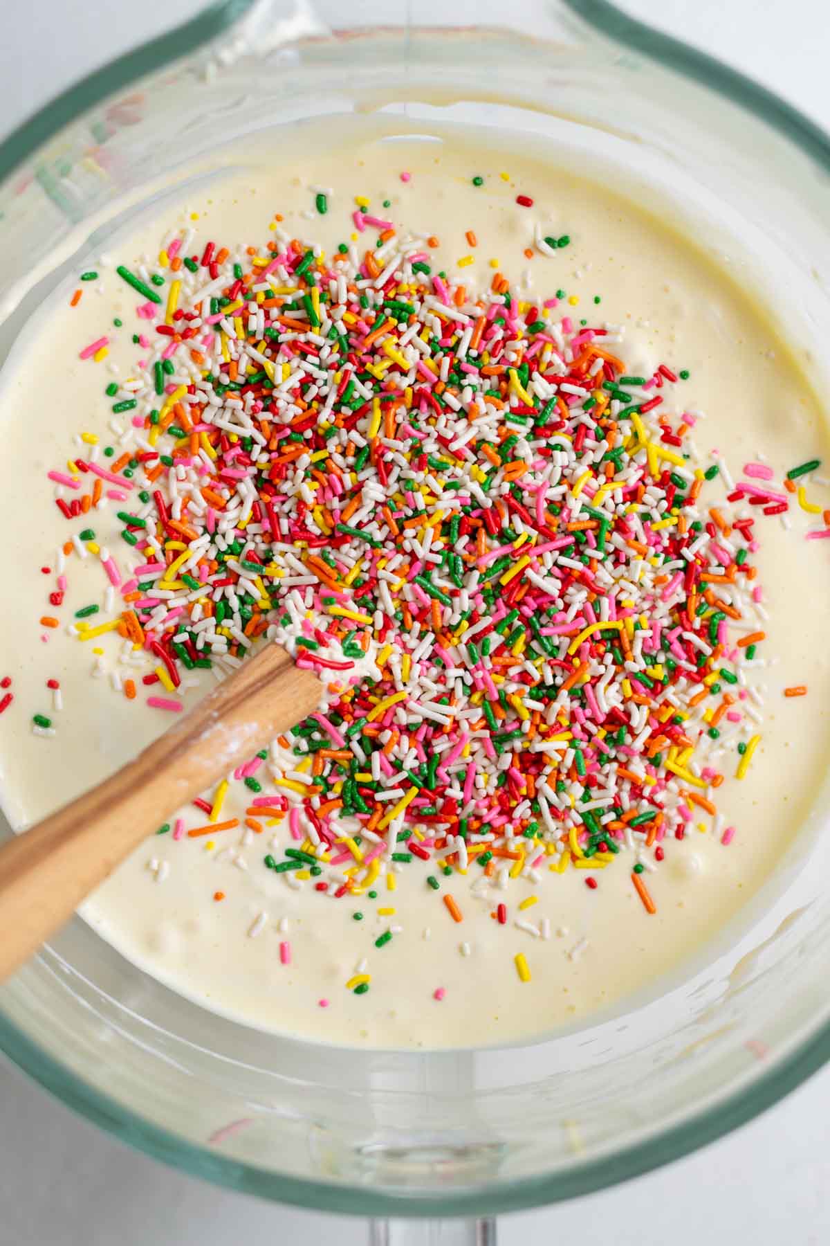sprinkles on top of cheesecake batter in a bowl