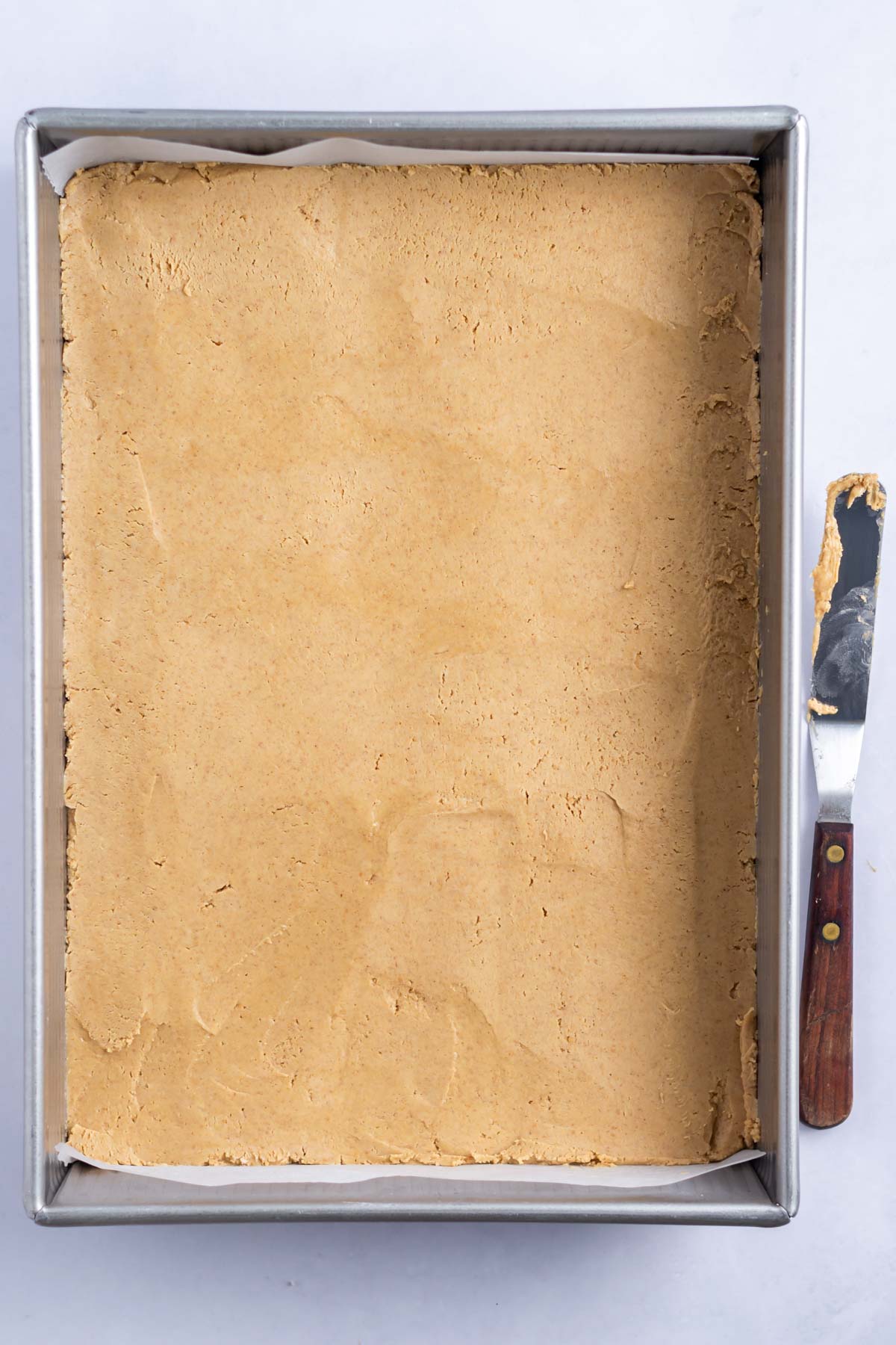peanut butter layer spread in the bottom of a baking pan