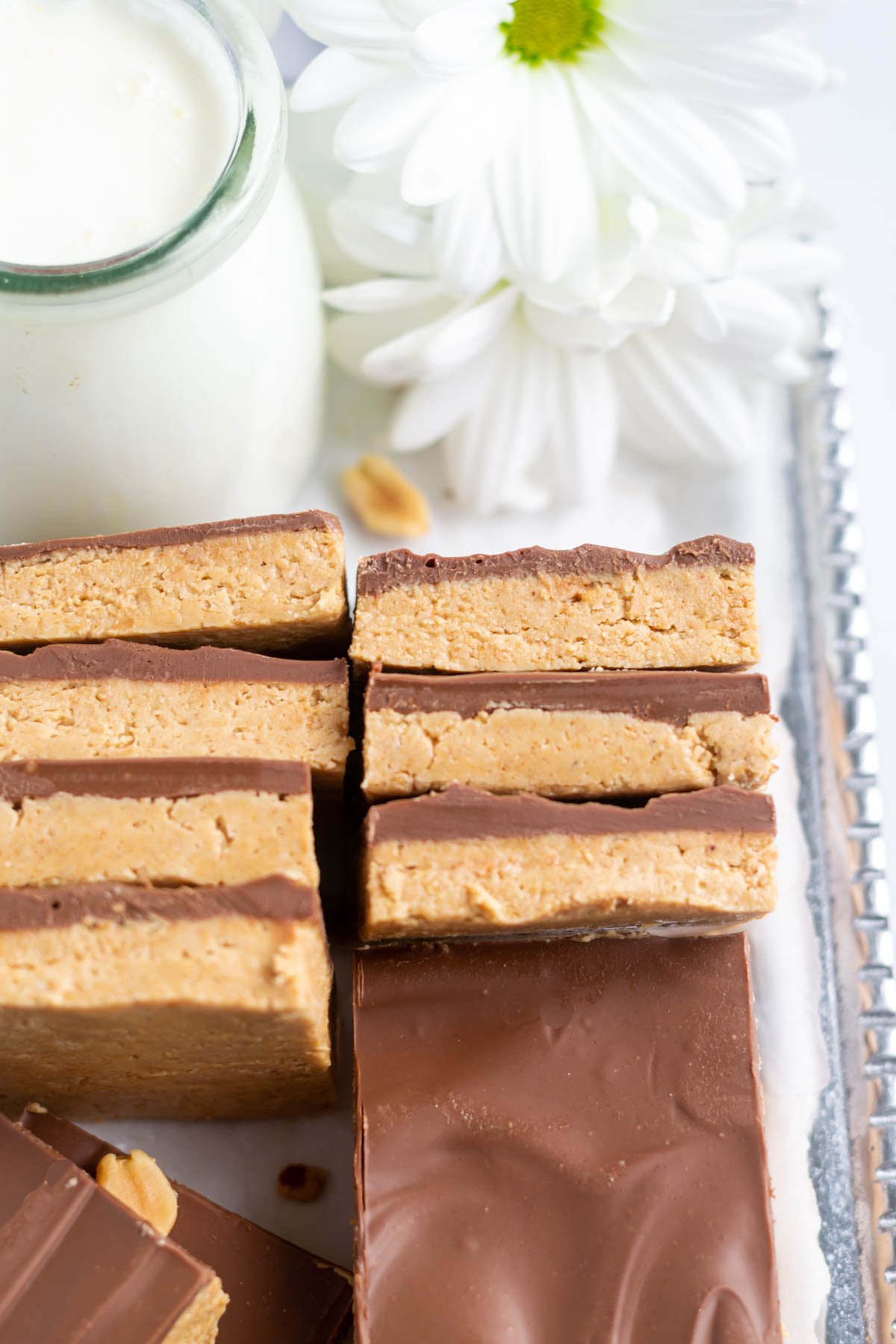 buckeye bars on a platter with flowers and milk