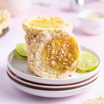 key lime cookie leaning against a stack of cookies on a plate