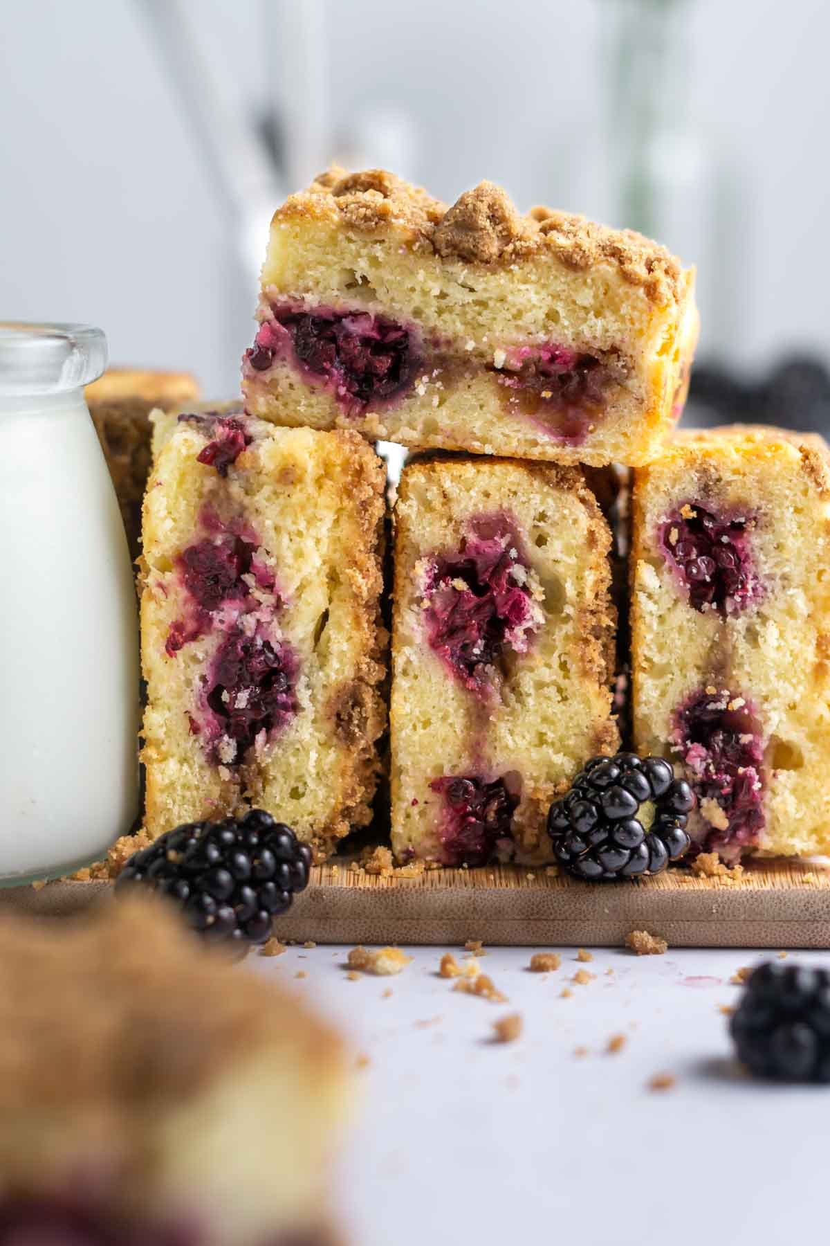 blackberry coffee cake slices piled on a cutting board