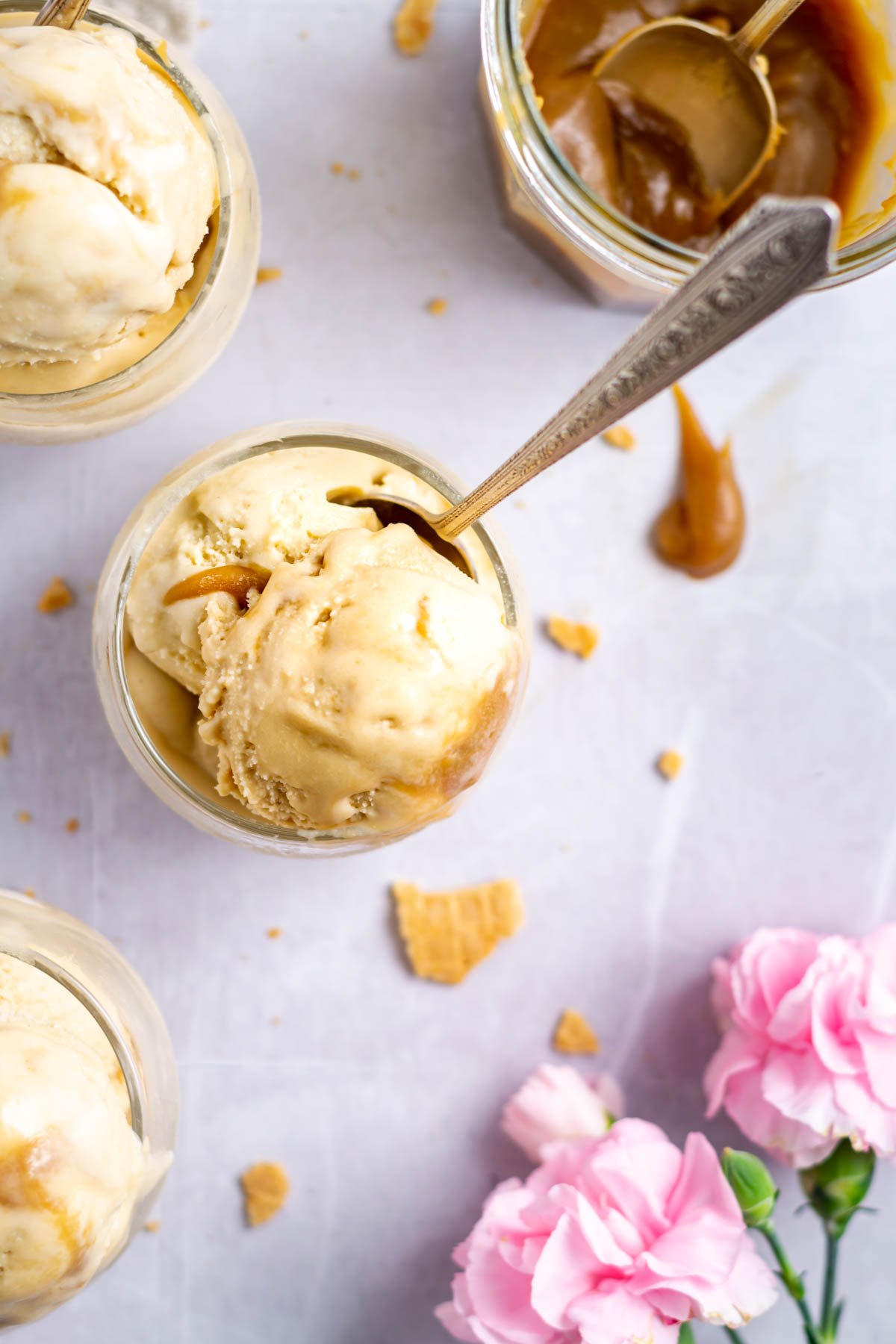 three bowls of ice cream with a jar of butterscotch