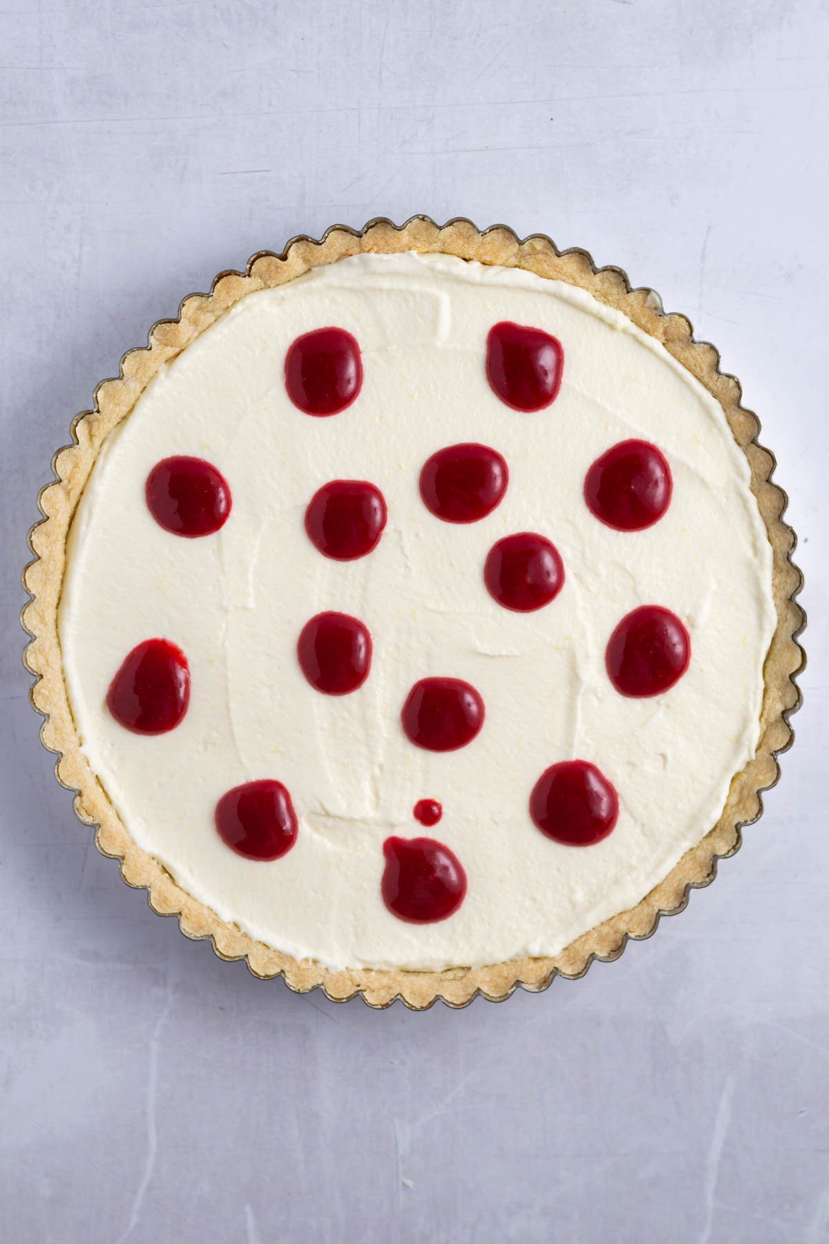 raspberry coulis dropped in circles over lemon filling