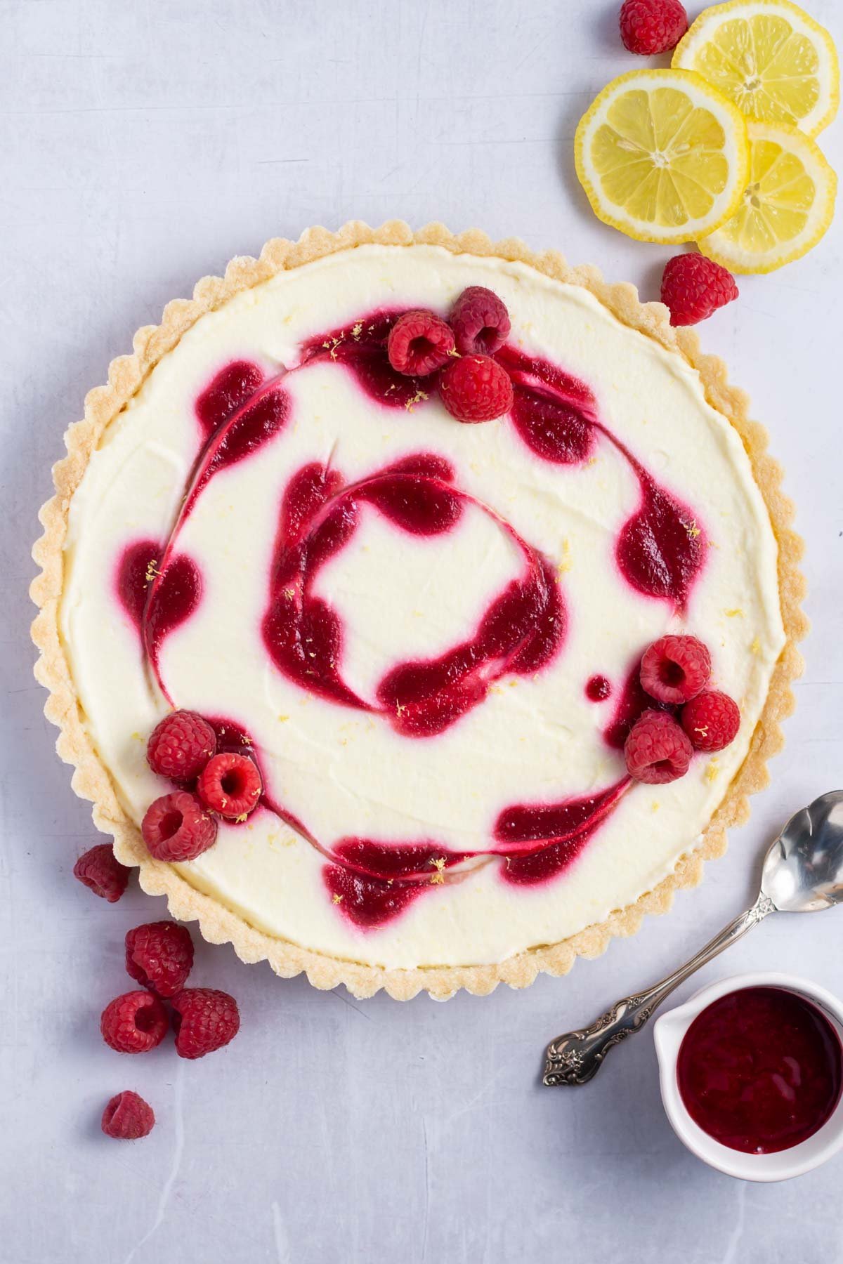 lemon raspberry tart with lemons and raspberry coulis