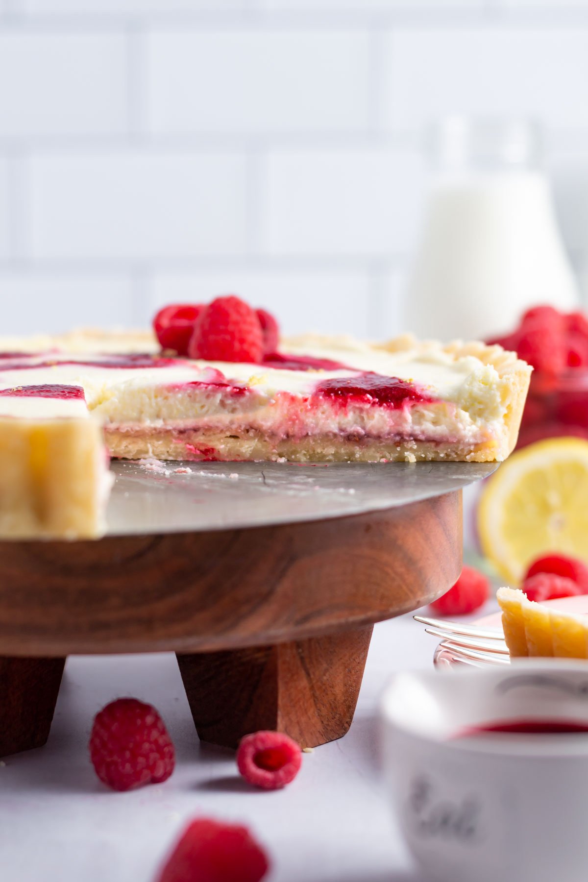lemon raspberry tart sitting on a cake stand