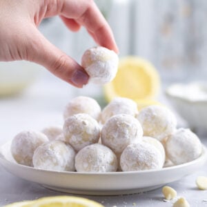hand grabbing a lemon truffle off a plate