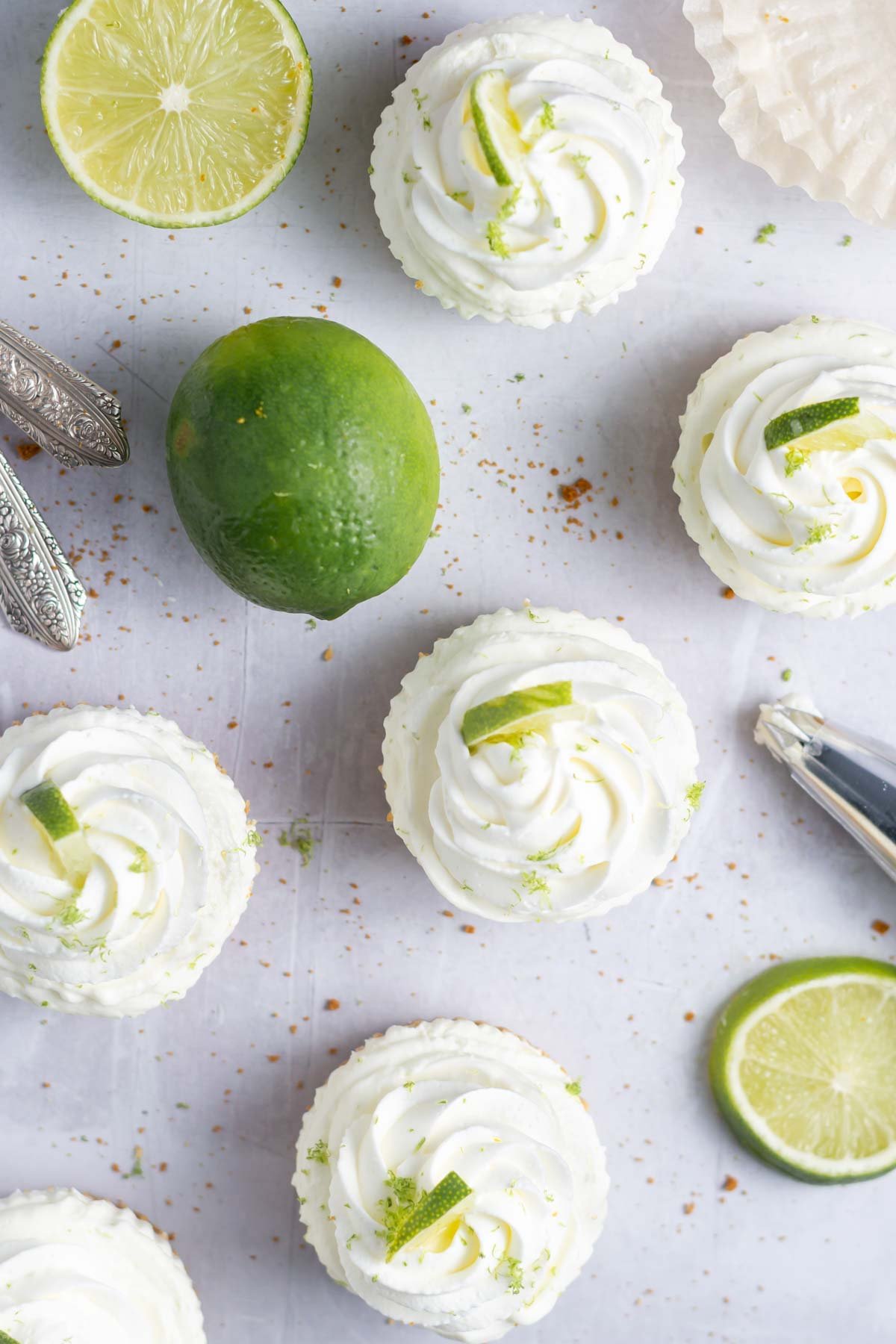 overhead look at whipped cream topped cheesecake and limes