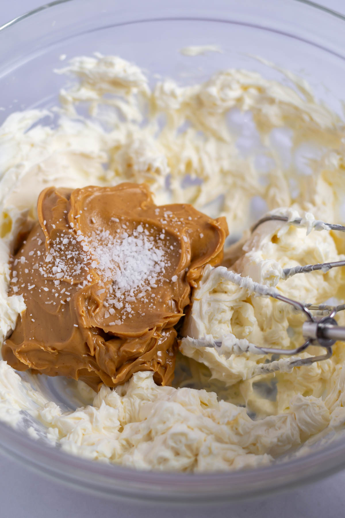 peanut butter and salt added to creamed cream cheese in a bowl