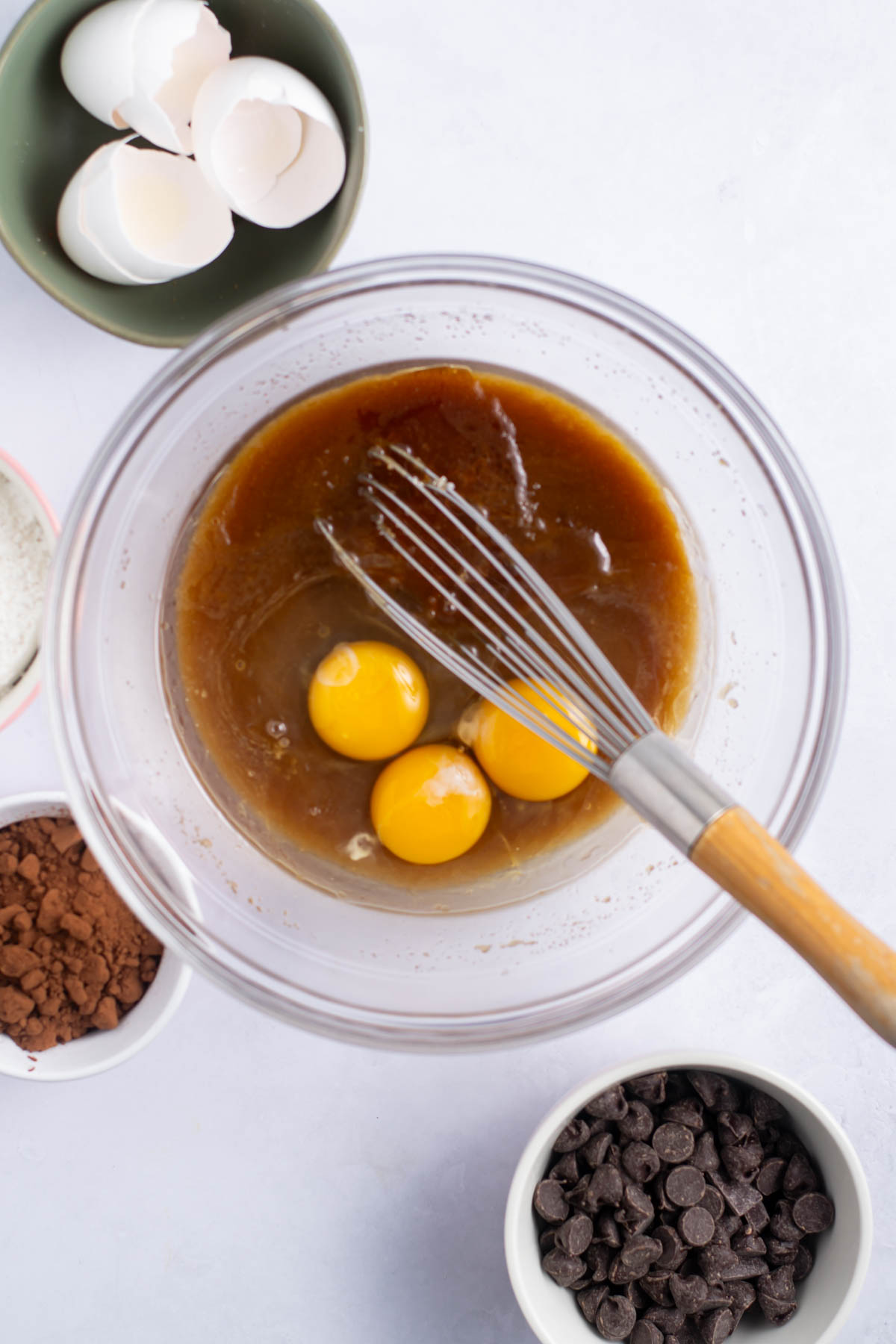 three eggs and vanilla added to the butter and sugar mixture in a bowl