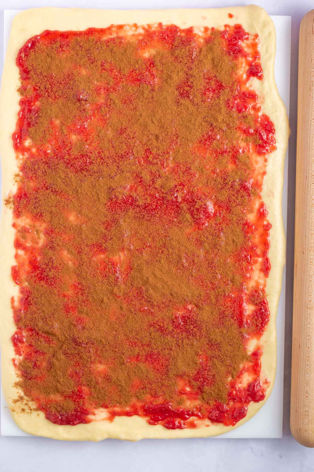 strawberry jam and cinnamon spread over dough