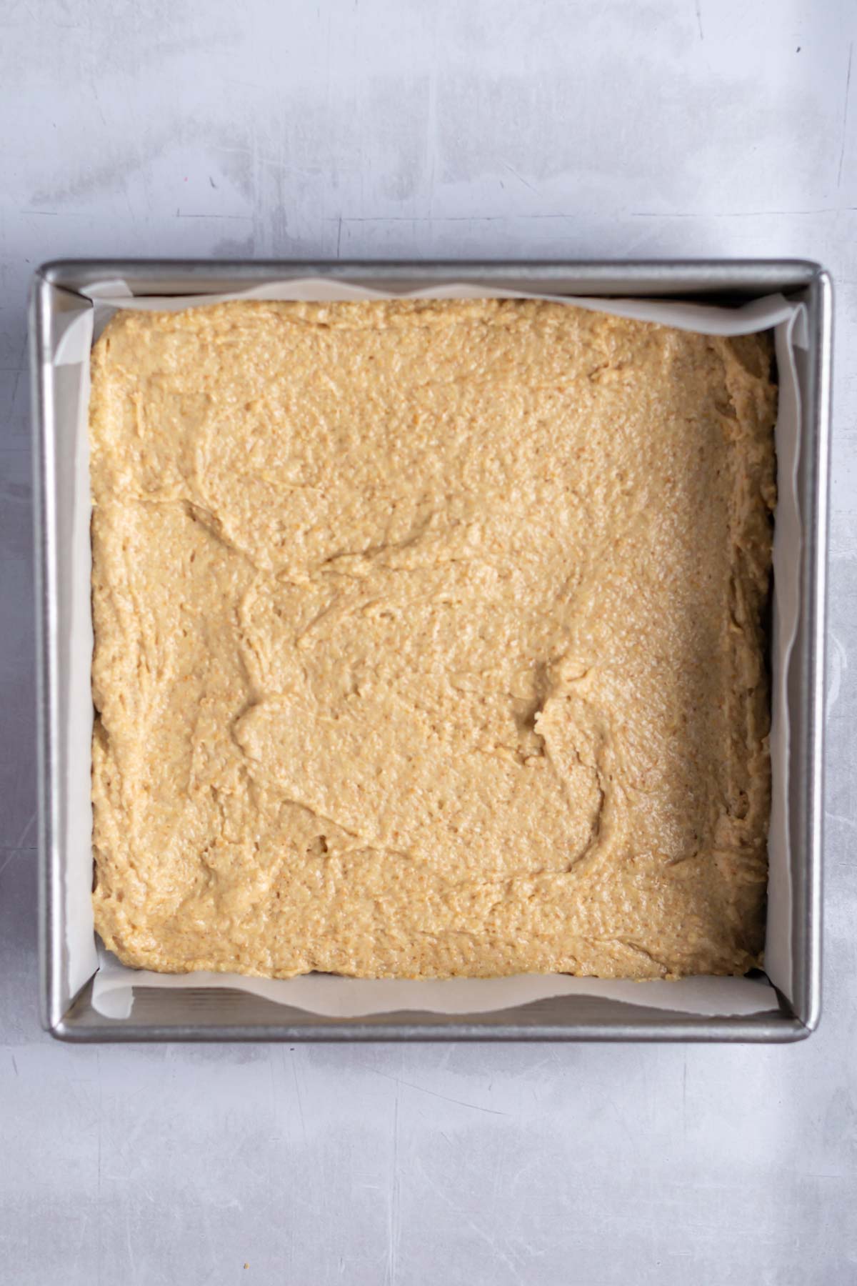 cake batter in a parchment lined baking tin