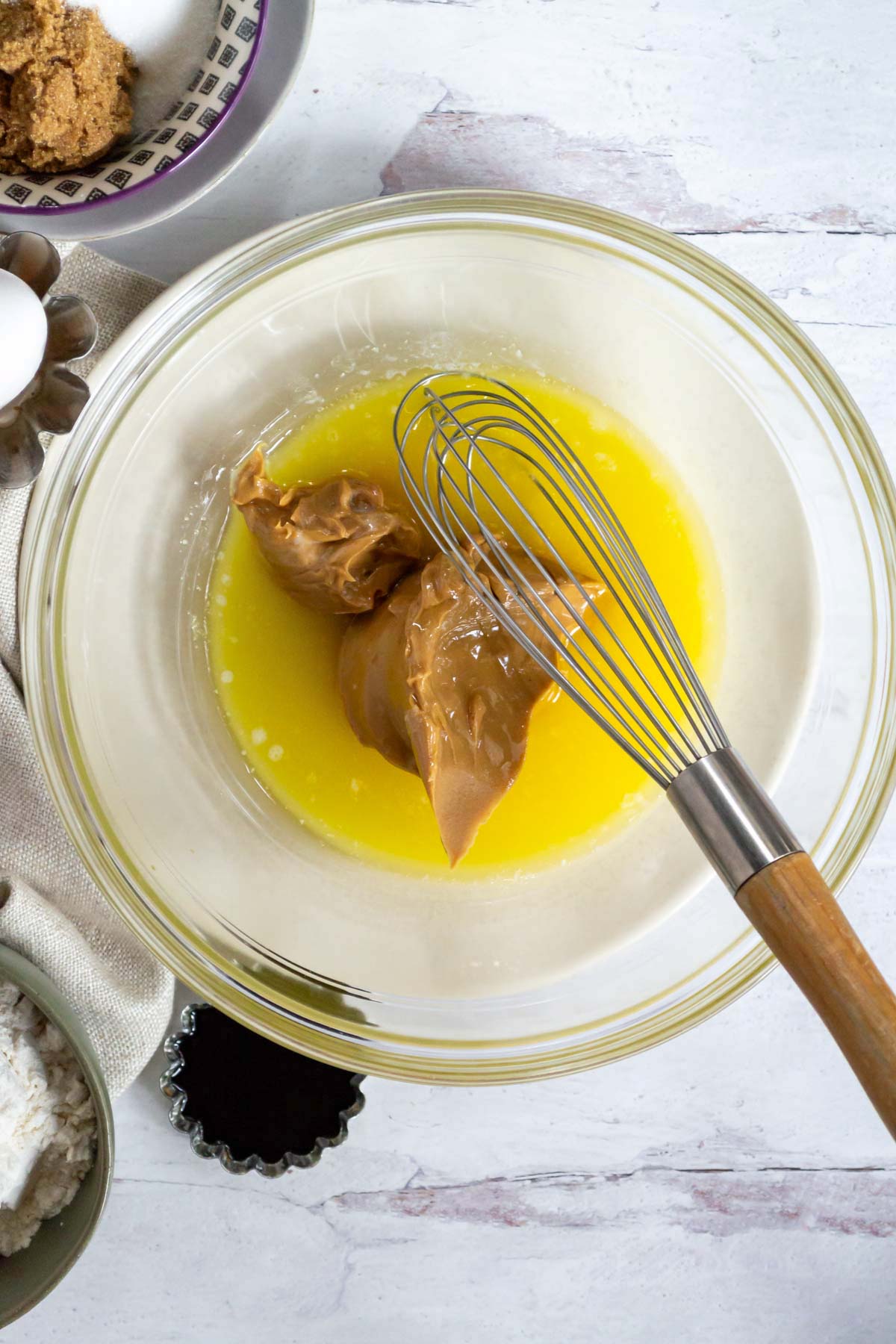 peanut butter and melted butter with a whisk in a mixing bowl