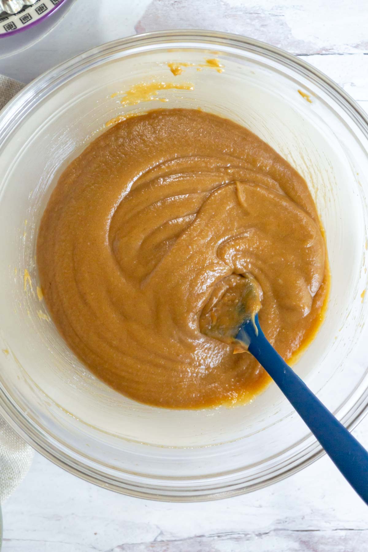peanut butter blondie batter in a mixing bowl with a spatula
