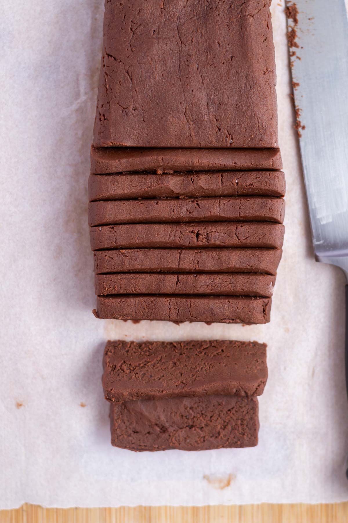 sliced chocolate shortbread on a parchment lined cutting board