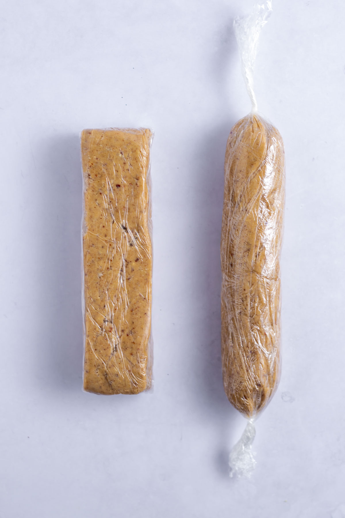 rectangular and circular log of dough wrapped in plastic