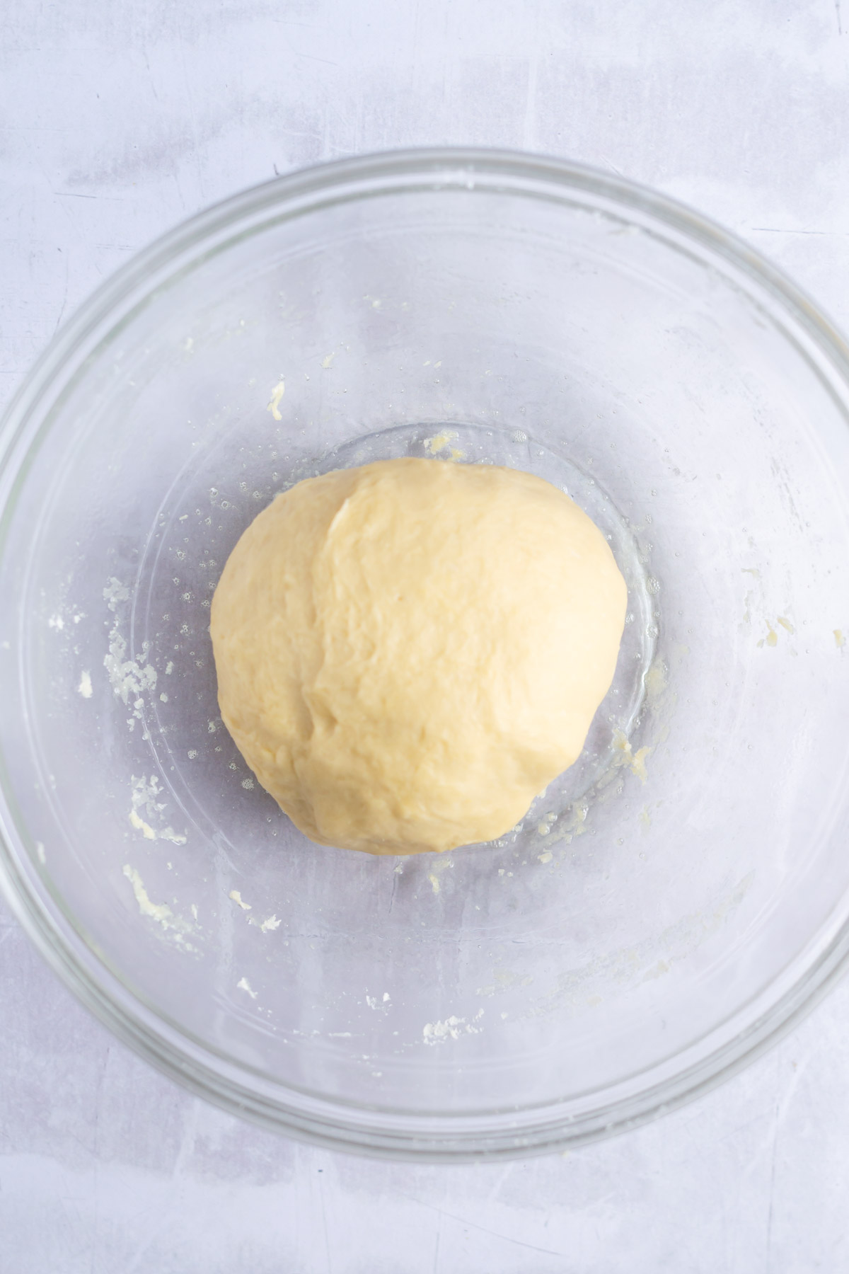 kneaded cinnamon roll dough placed in a greased bowl