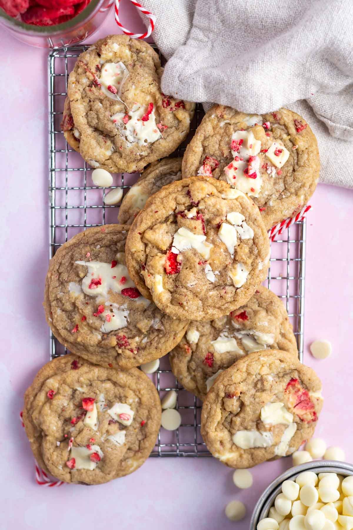 cookies on a cooling rack with a napkin and bowls of white chocolate and strawberries