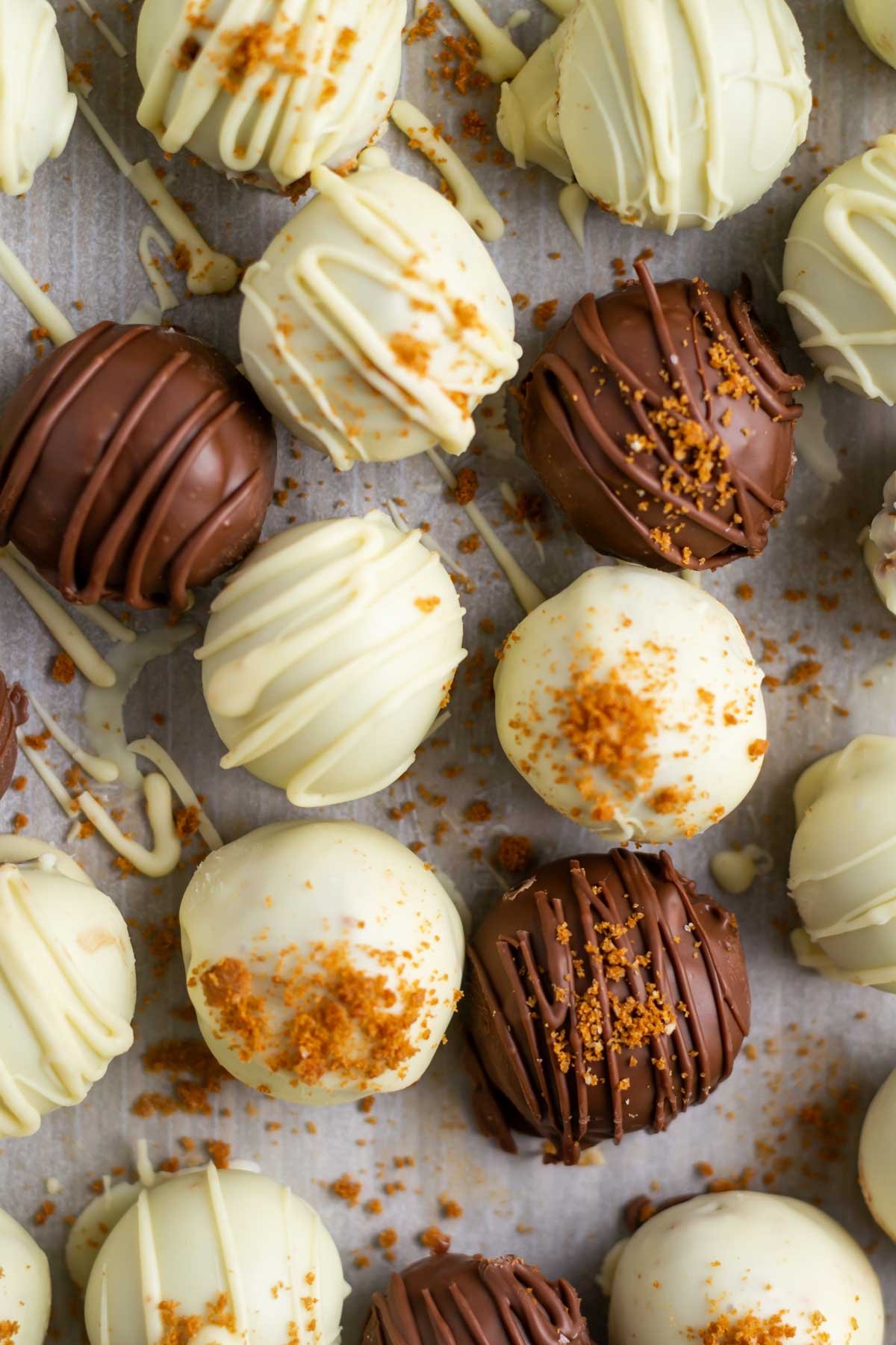 white and dark chocolate dipped biscoff truffles on parchment paper
