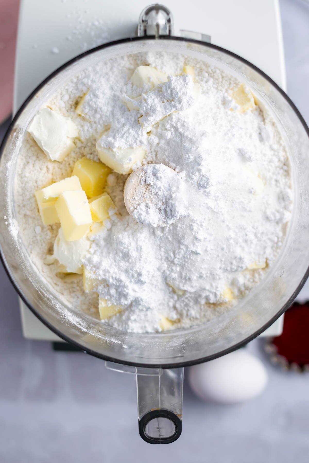 flour, butter, cream cheese and sugars in the bowl of a food processor.