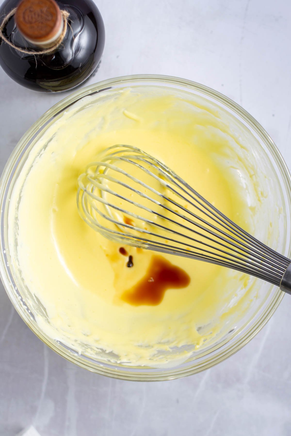 vanilla added to the custard in a bowl with a whisk