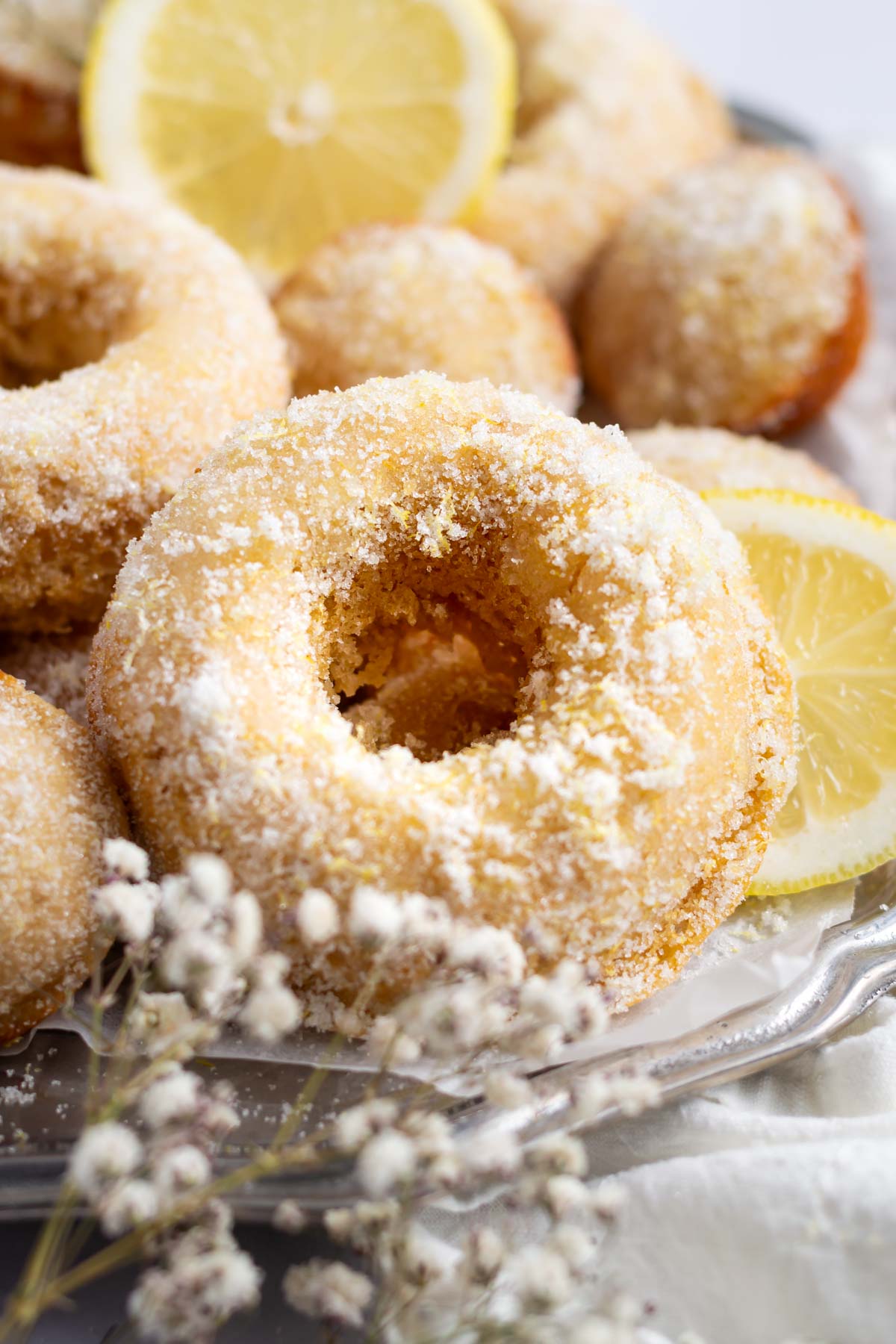 donuts with lemon sugar on a plate with lemon slices