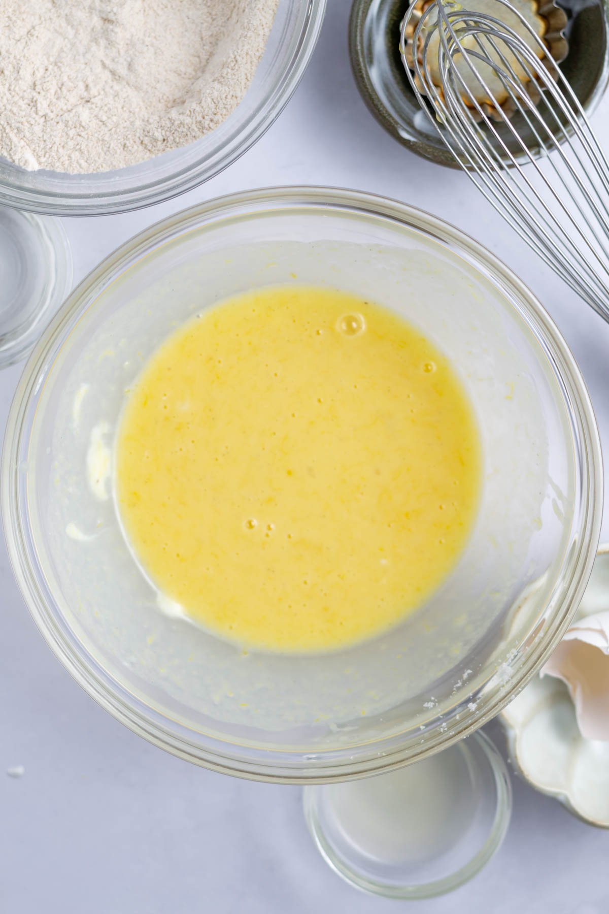 egg, lemon zest, sugar, vanilla, and greek yogurt whisked together in a mixing bowl.