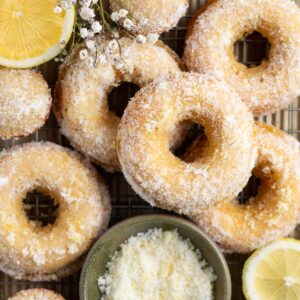 lemon donuts on a cooling rack with lemon slices