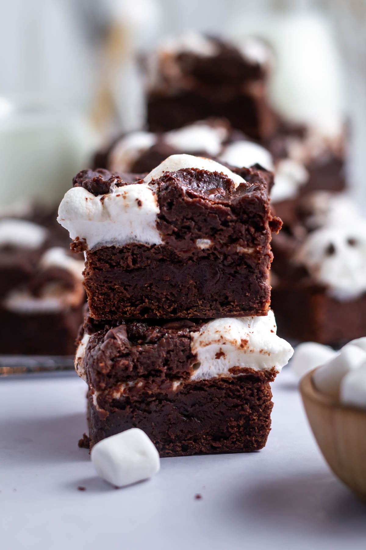 stack of marshmallow brownies with a bowl of marshmallows in the foreground