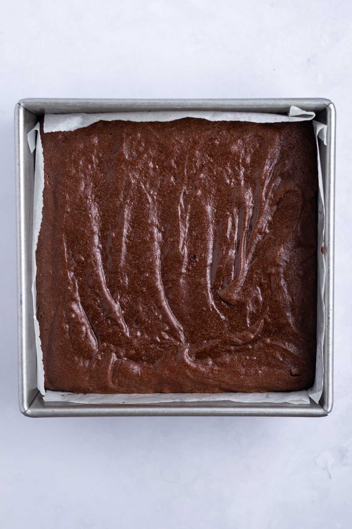 baked brownies in a parchment lined pan