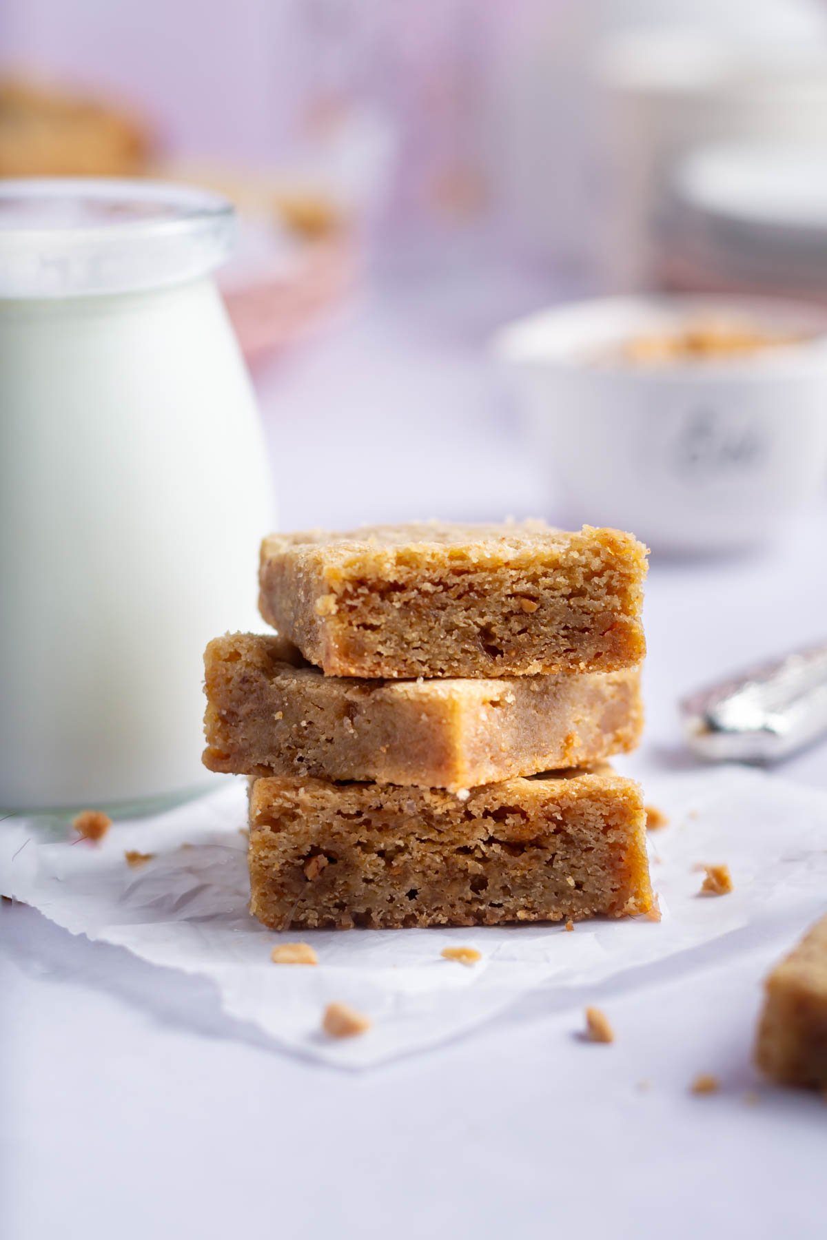 stack of blondies with a glass of milk