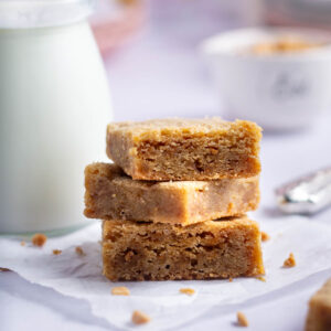 stack of browned butter blondies with a glass of milk
