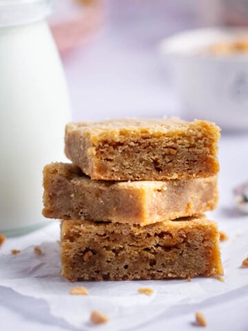 stack of browned butter blondies with a glass of milk