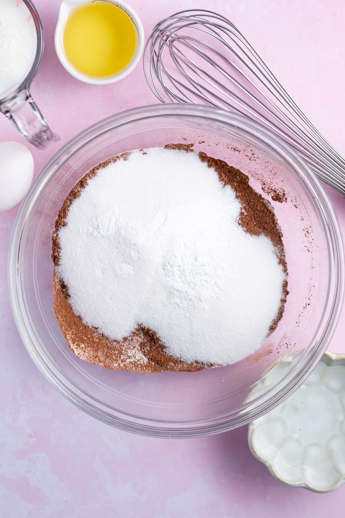 flour, sugar, baking soda and kosher salt in a mixing bowl with a whisk nearby.