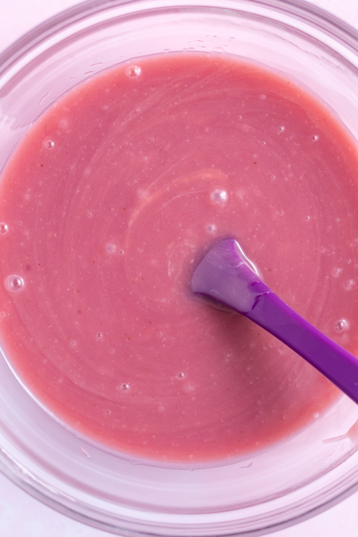 raspberry ganache in a mixing bowl with a spatula