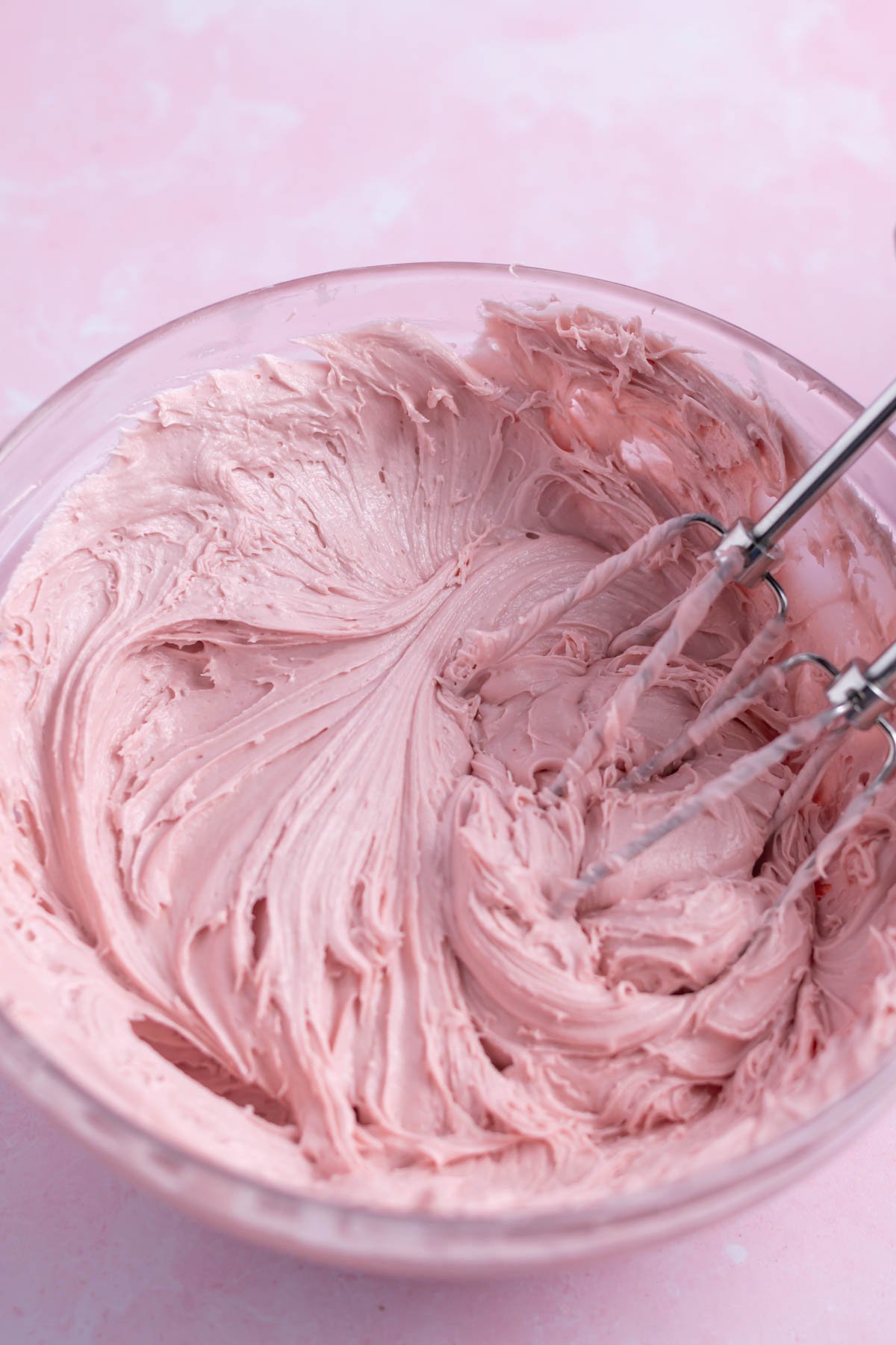 raspberry ganache in a mixing bowl with the mixing beaters.