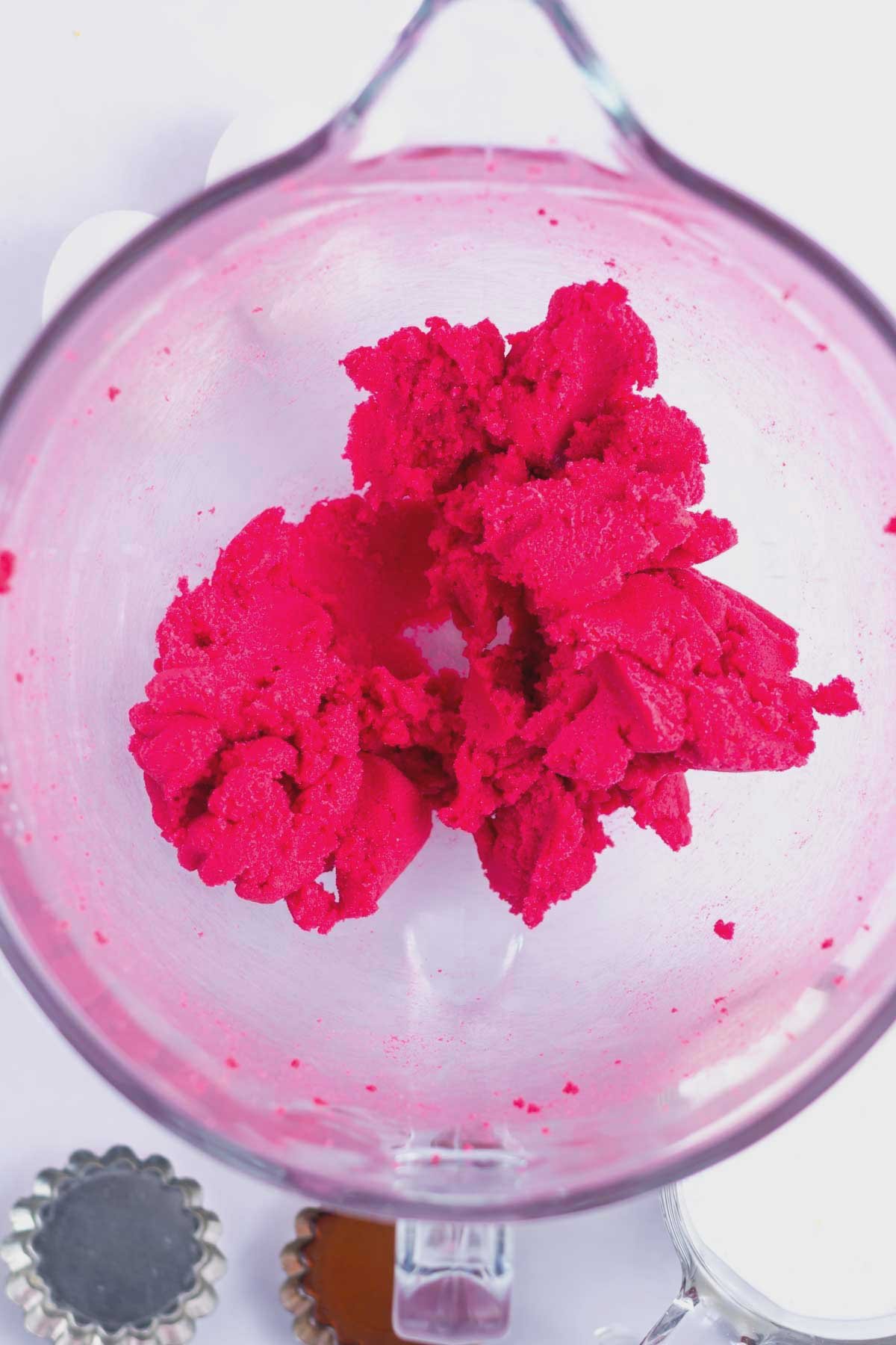 butter, pink food coloring and sugar beat together in a mixing bowl