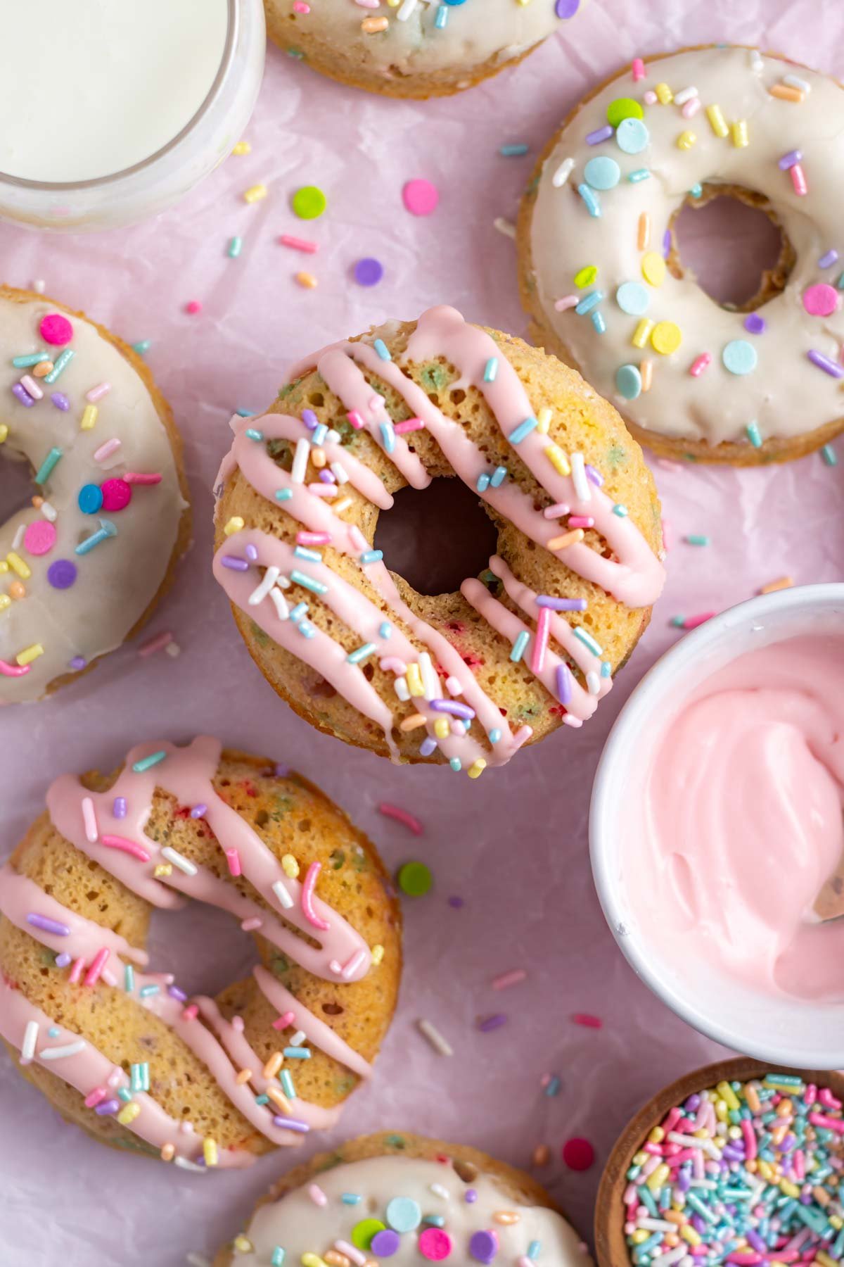 pink drizzle and white glaze on donuts with milk