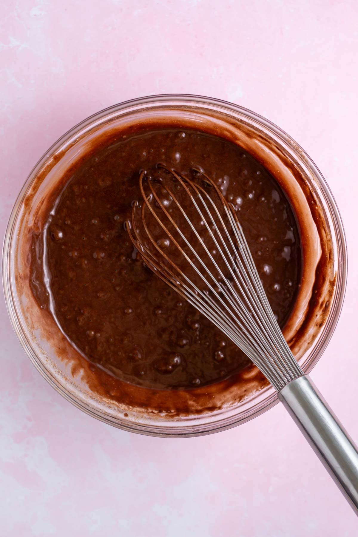 chocolate cake batter in a bowl with a whisk
