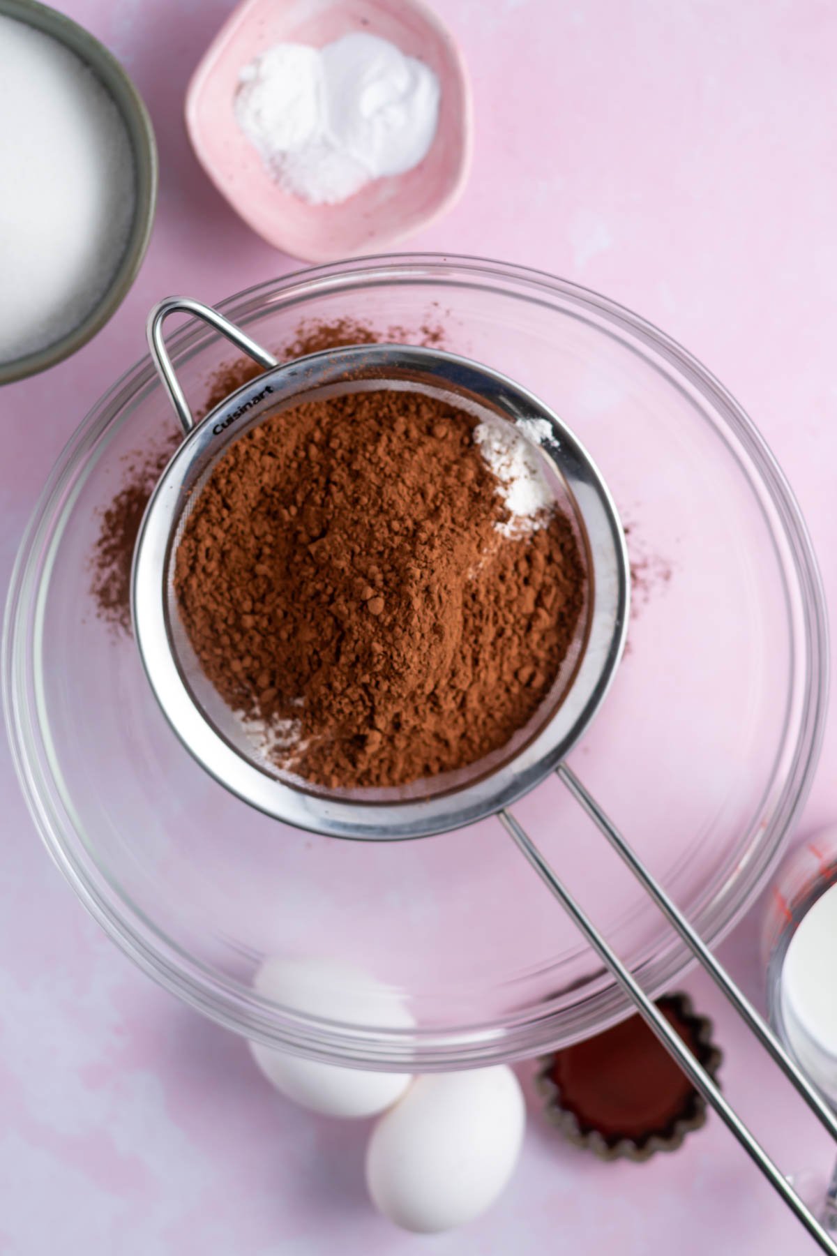 cocoa powder and flour in a sifter over a glass bowl