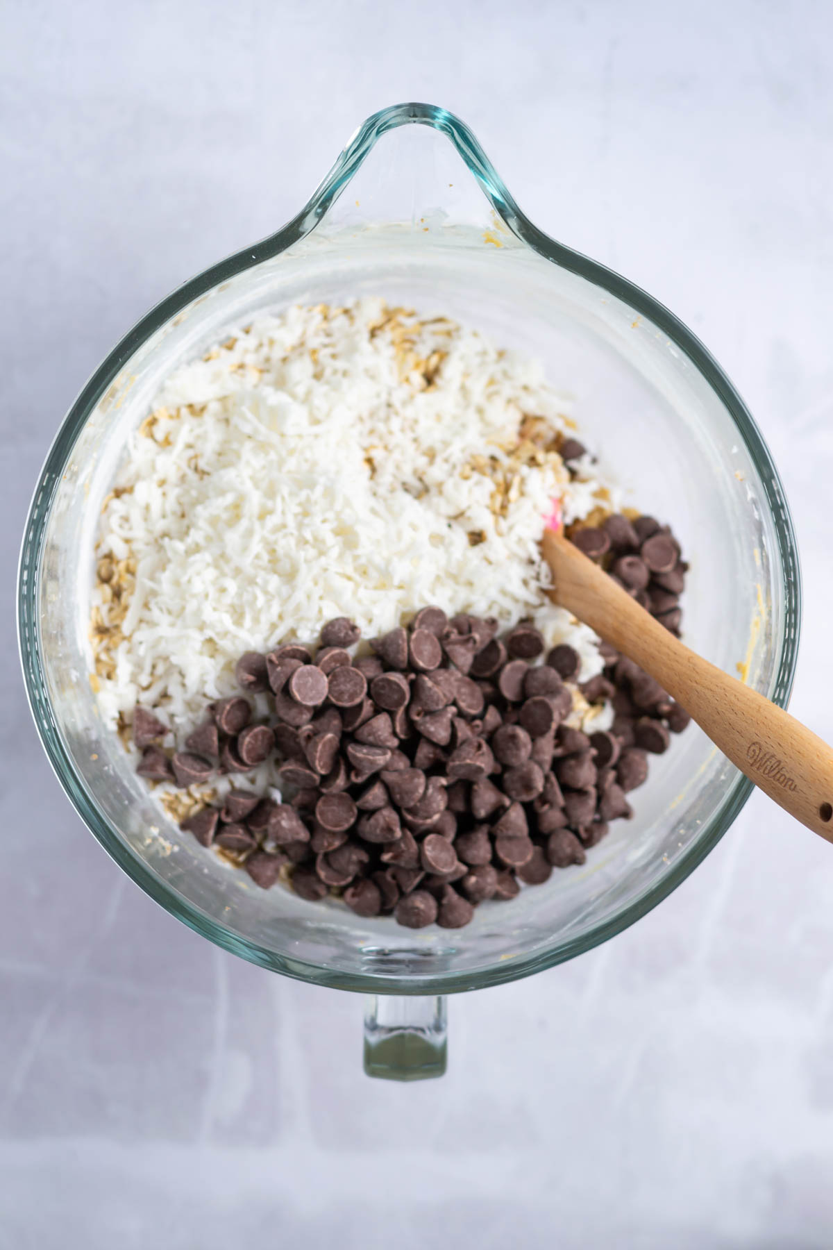 coconut and chocolate chips in a mixing bowl of cookie dough