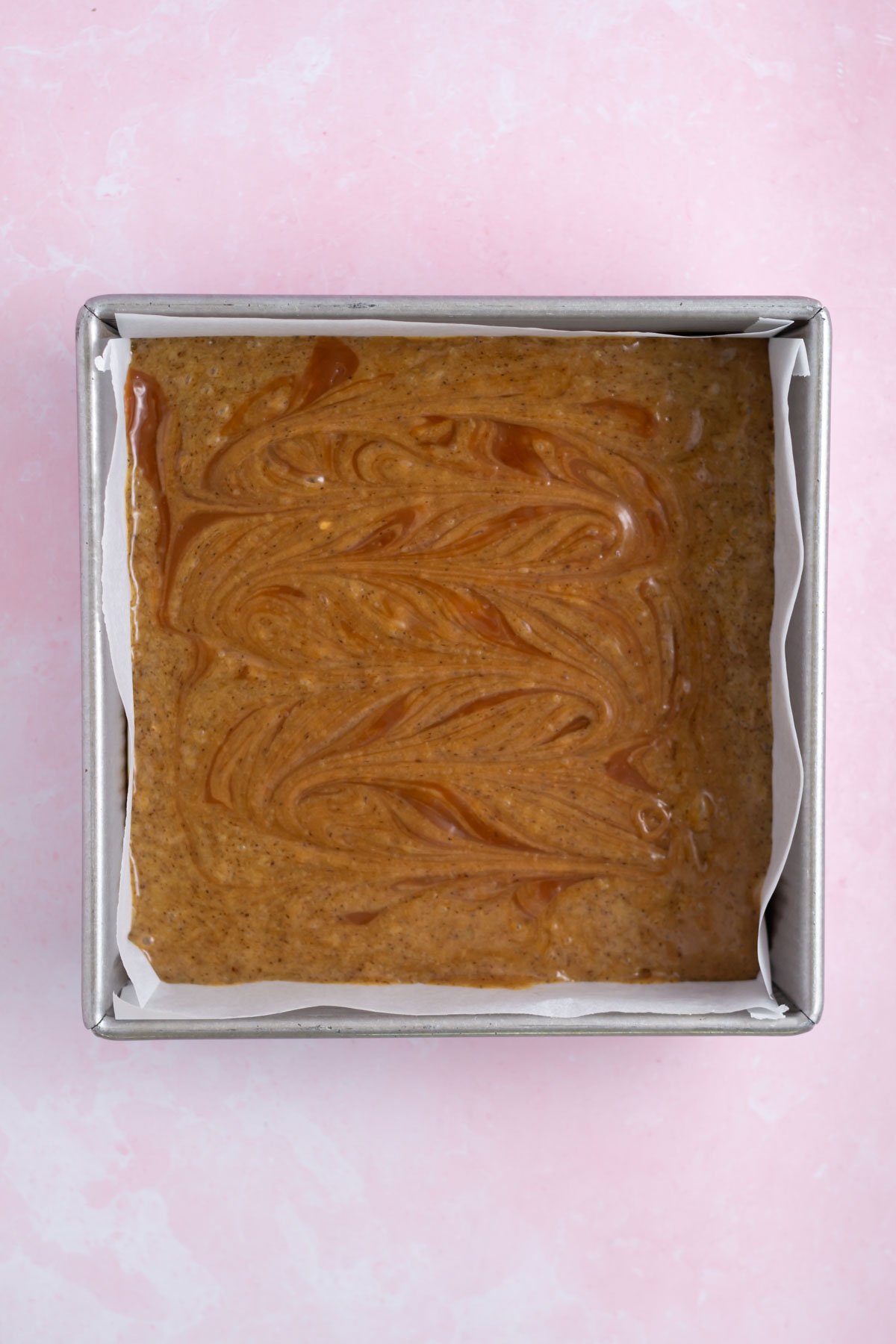 swirled caramel into brownie batter in a baking pan
