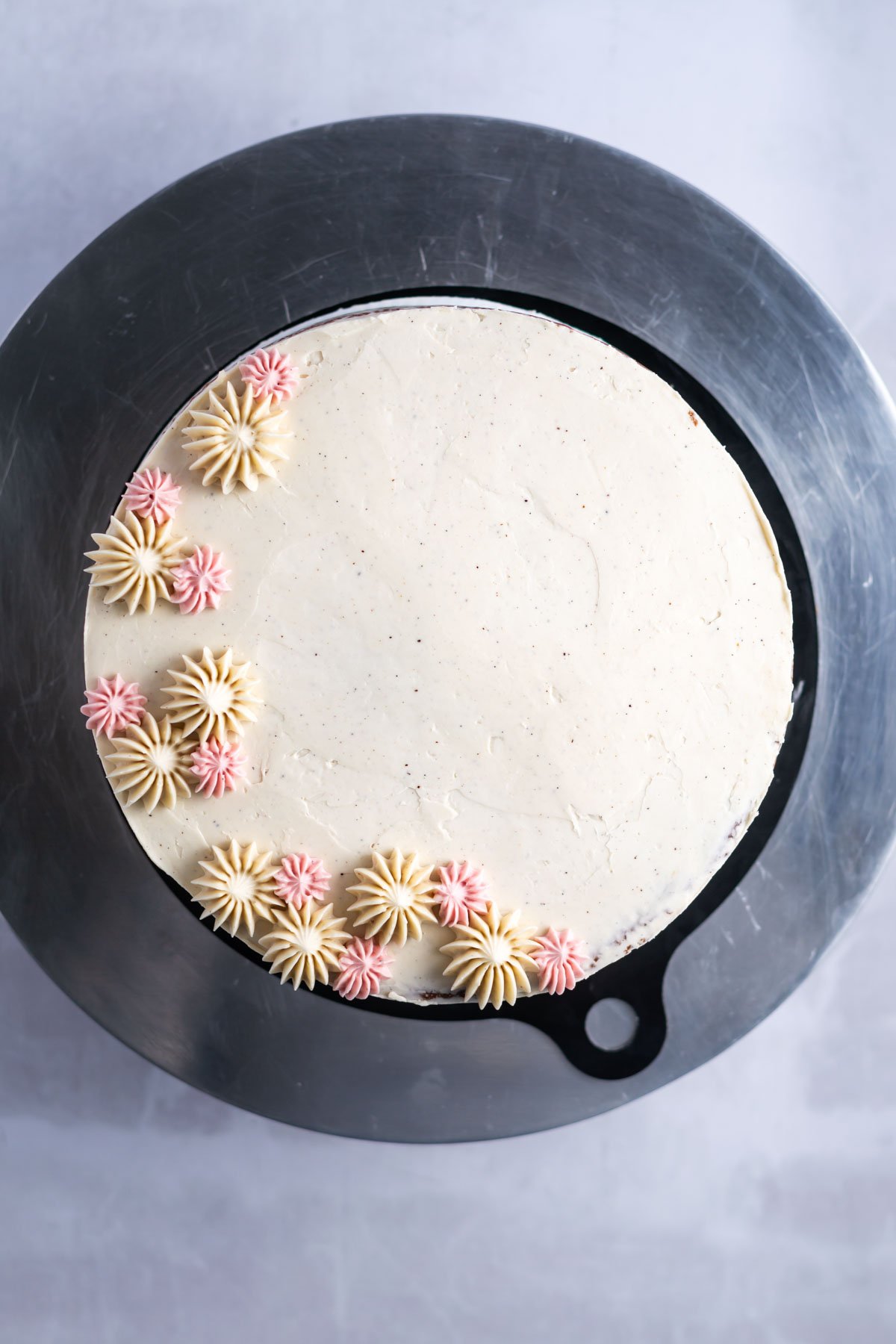 pink and cream colored piping on a cake top