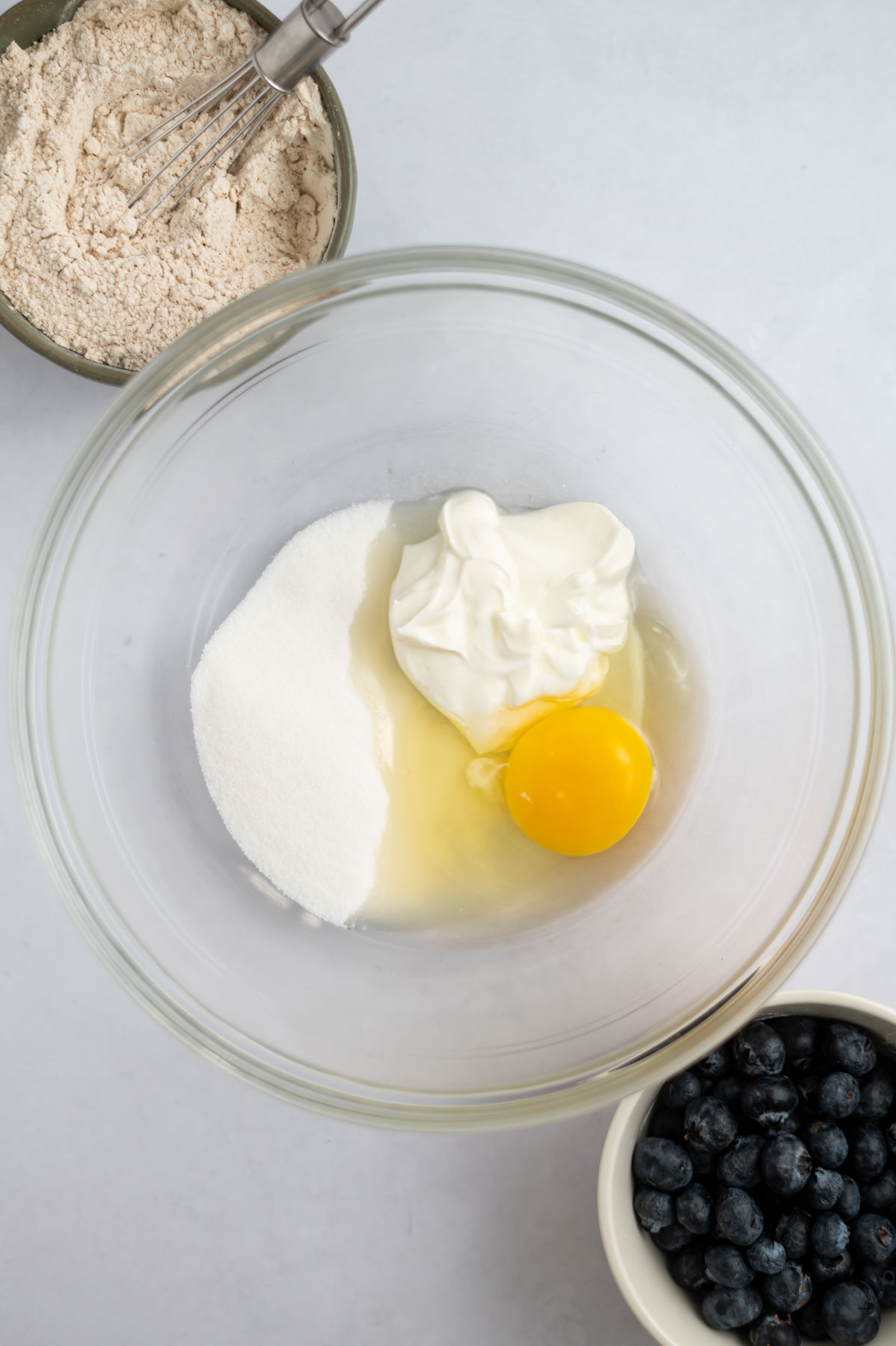sugar, sour cream and an egg in a bowl